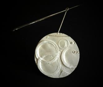  Angelo Rinaldi, Arte da indossare, scultura circolare in argento a fusione, con girocollo in argento, unico esemplare,datato 2010